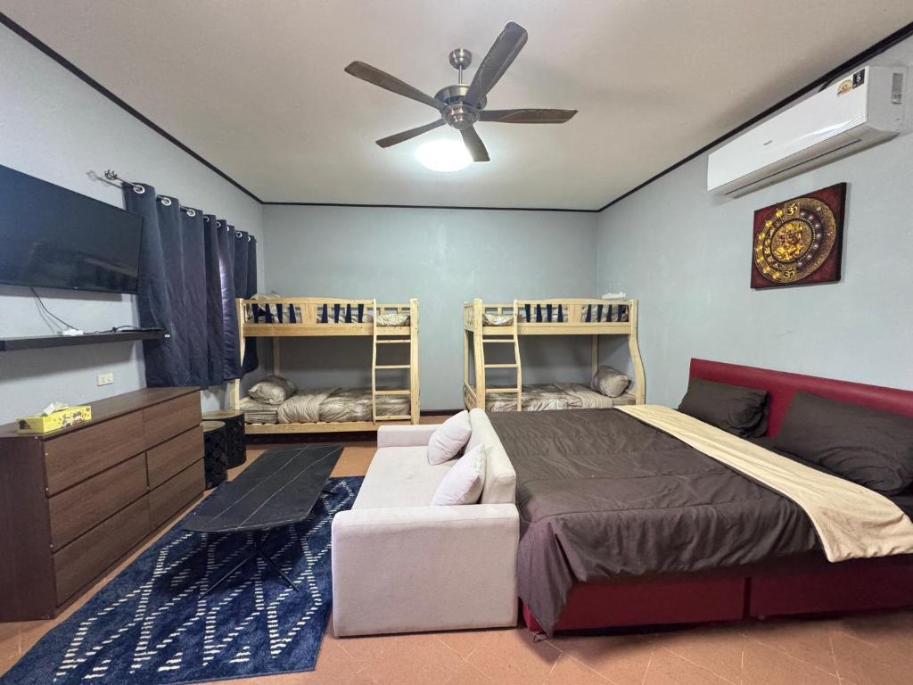 een slaapkamer met een bed en een plafondventilator bij Saensuk stay in Ban Wang Thong