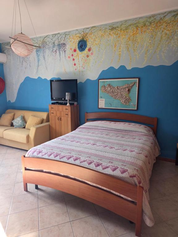 PERLA VERDE Rooms and parking في Case Nuove: غرفة نوم مع سرير مع خريطة على الحائط