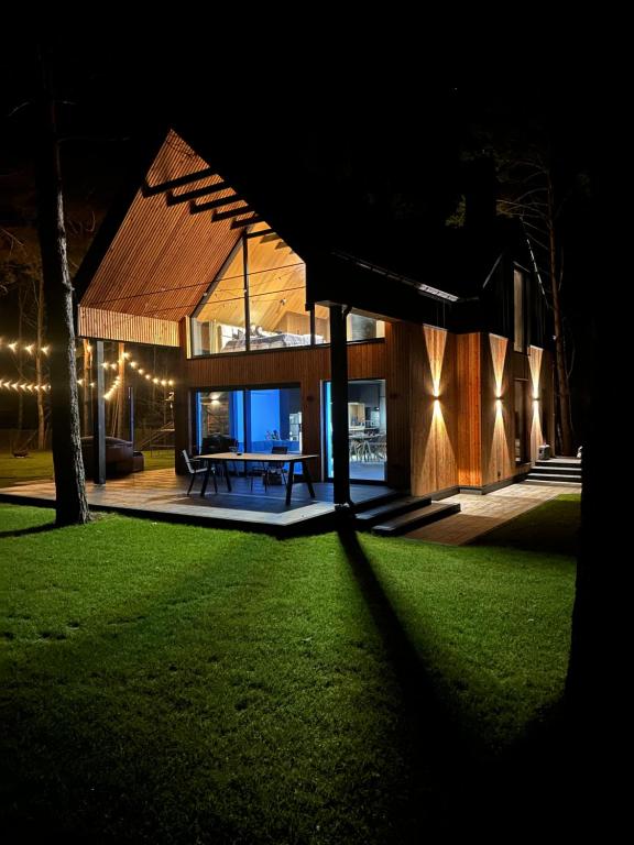 a house at night with a table in the yard at Chata w Puszczy Nowa Łuka in Łuka