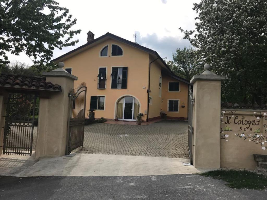 a large yellow house with a gate and a driveway at Il cotogno in Carrosio