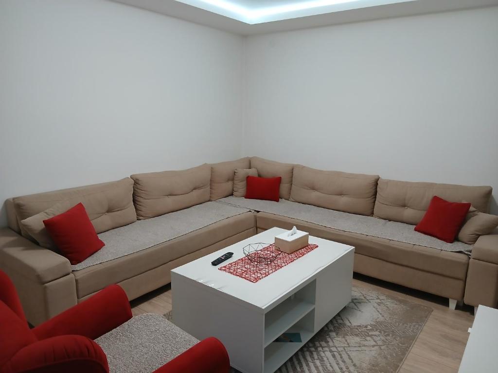 a living room with a brown couch with red pillows at Novi Priboj in Čitluk
