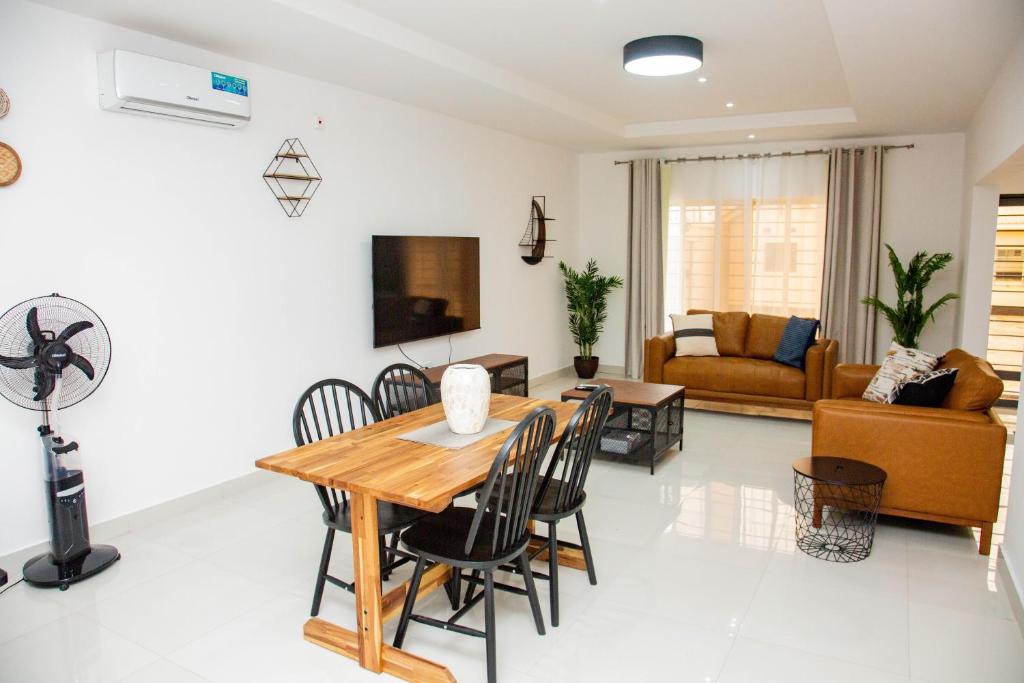 Zanube Apartments في ندولا: غرفة طعام وغرفة معيشة مع طاولة وكراسي