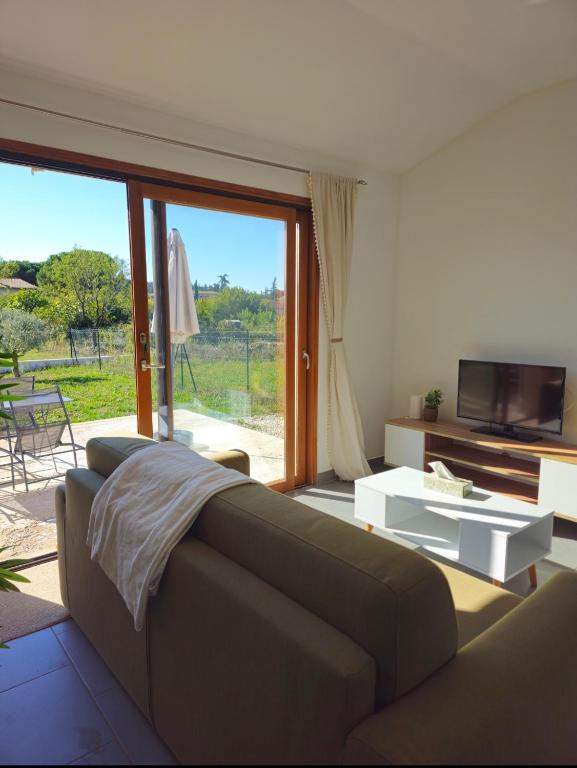 a living room with a couch and a large window at L'Ardèchois in Saint-Remèze