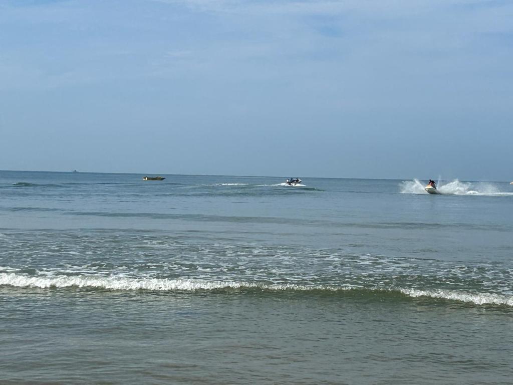 a group of people riding waves in the ocean at Serena Casa in Mobor Goa