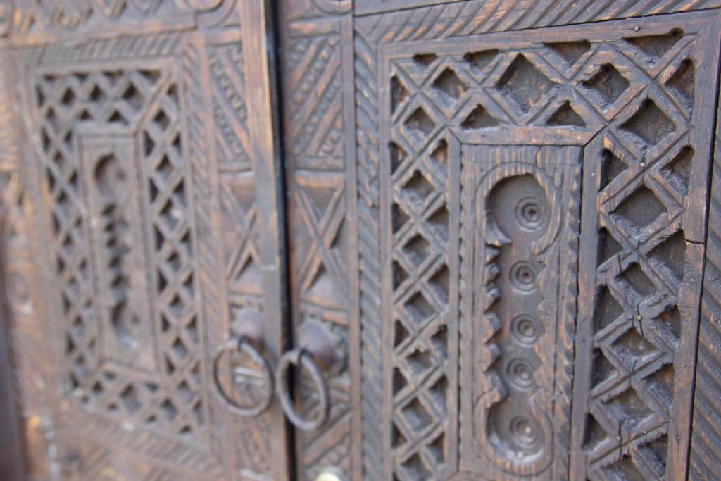 una porta di legno con disegni intricati di Riad La Rose Orientale Marrakech a Marrakech