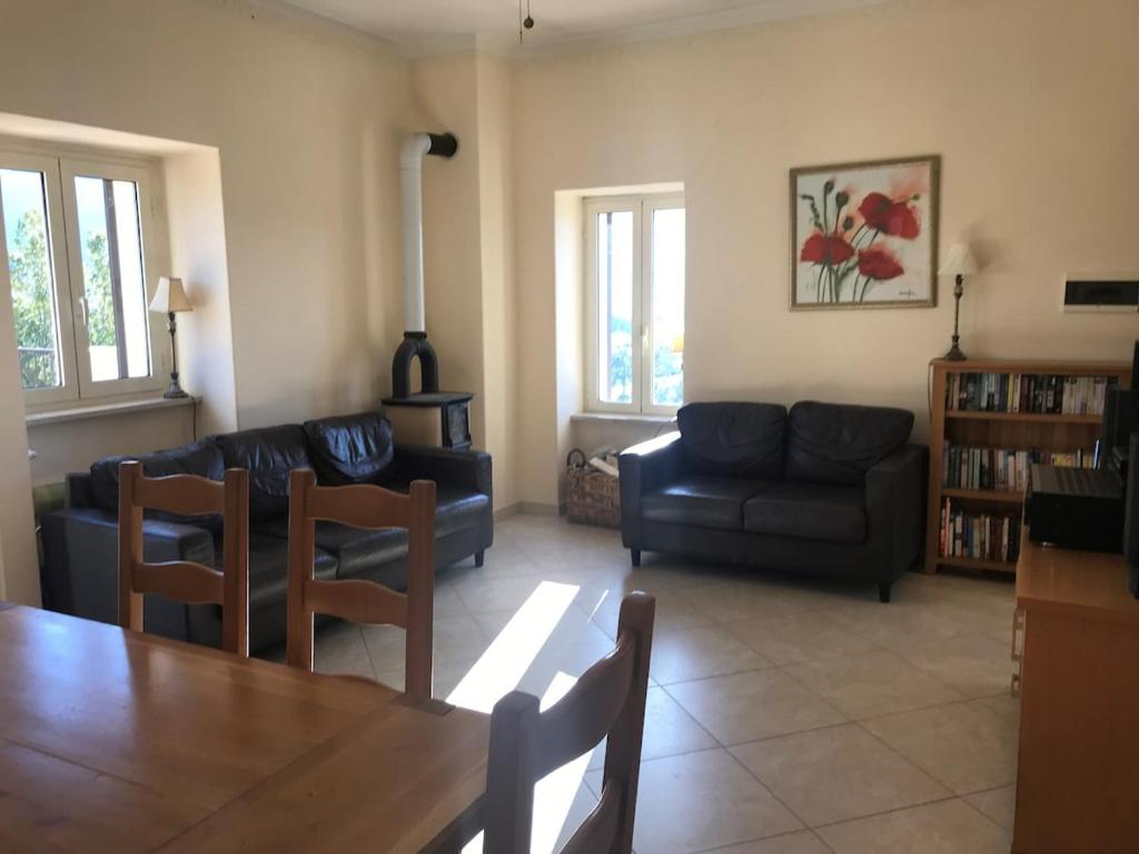 Una sala de estar con un sofá, una mesa y sillas. en Amazing Terrace Colle Posta, 3 Bedr, Picinisco, 