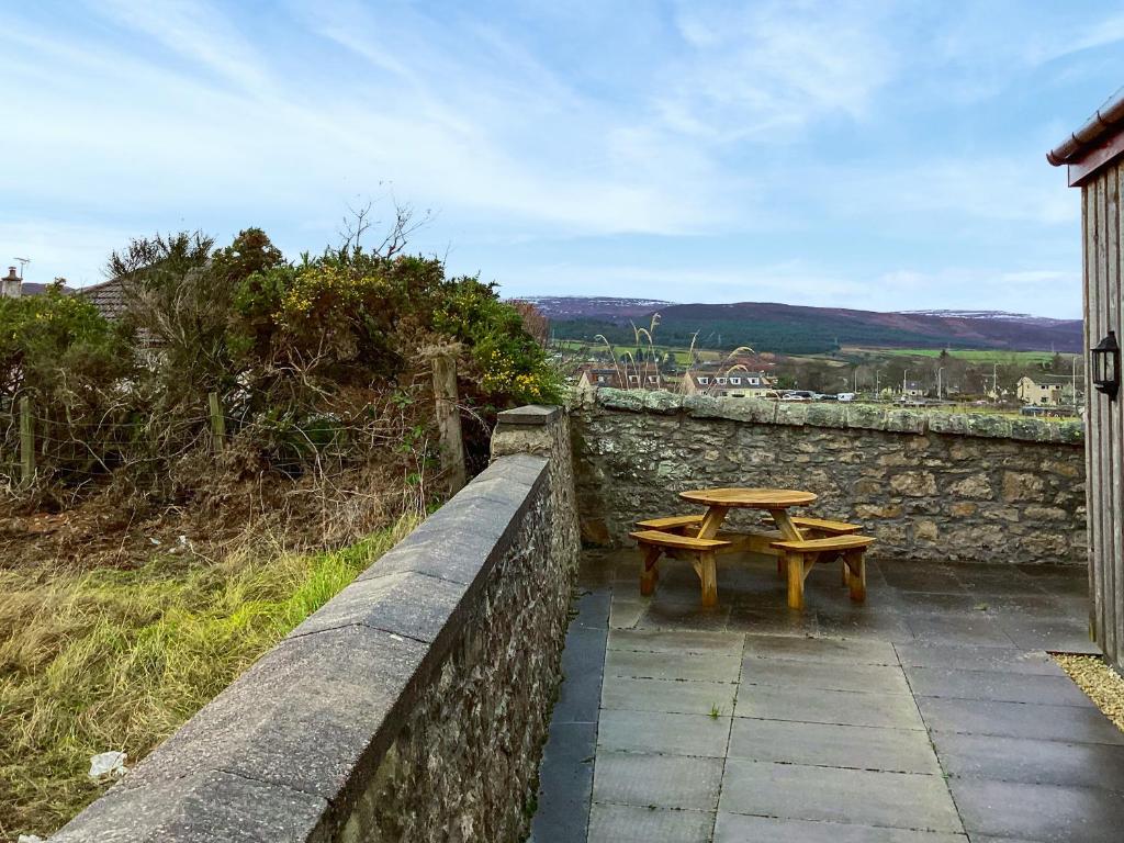 a table and two benches on a stone wall at Mirodon in Brora