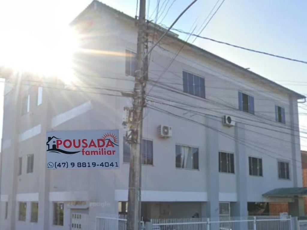 a white building with a sign on the side of it at Pousada Familiar 10 in Rio do Sul