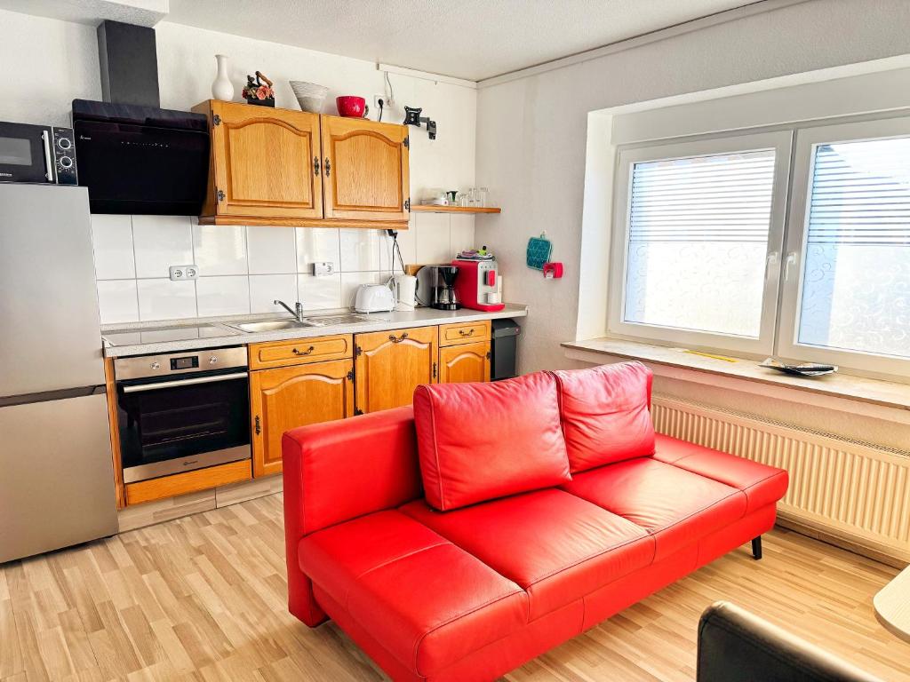 een woonkamer met een rode bank in een keuken bij EG Einzel-Apartment - 24h Check In in Harpendorf