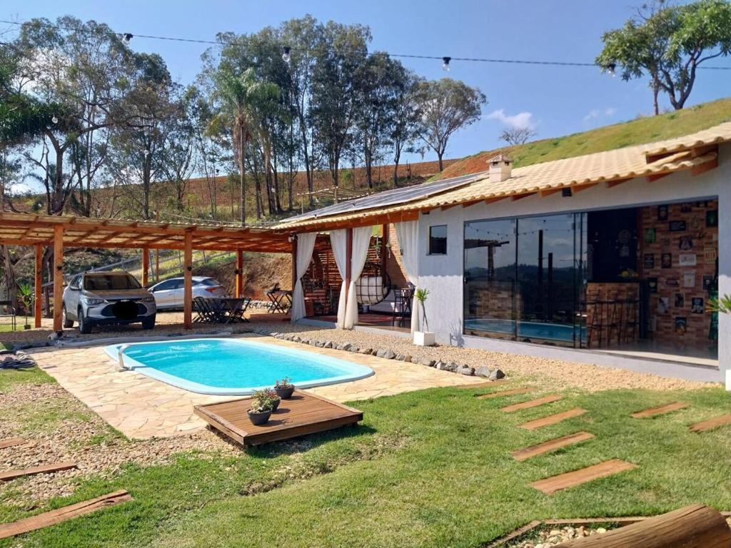a house with a swimming pool in the yard at Chácara Bela Vista in Itajubá
