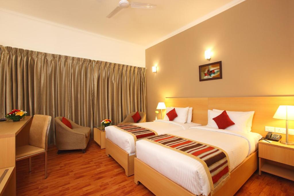 Postel nebo postele na pokoji v ubytování Starlit Suites Kochi