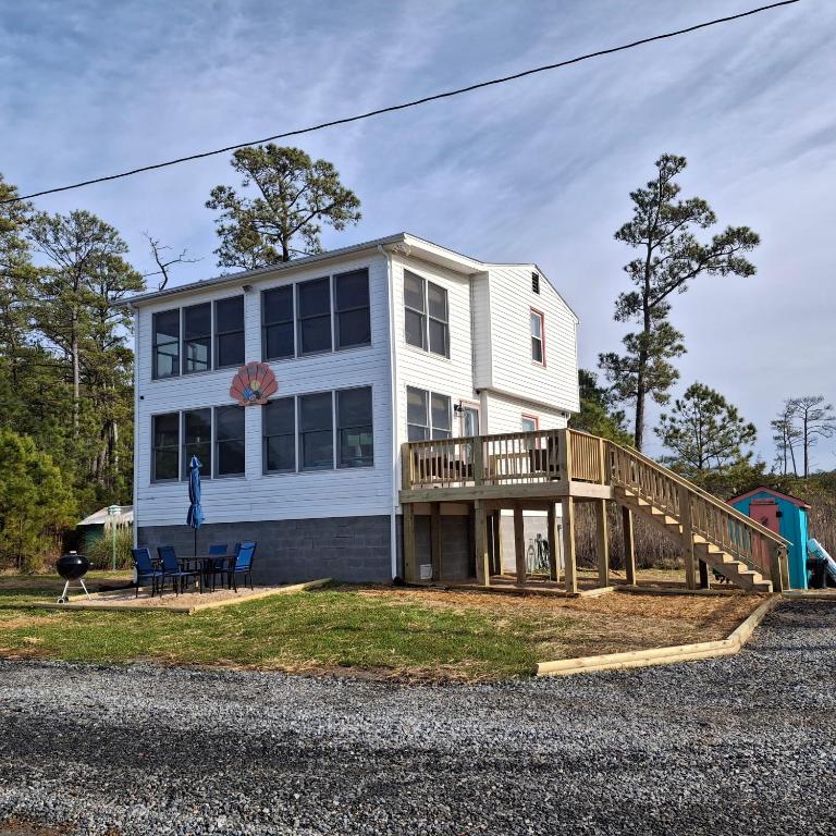 a large white house with a wooden deck at Little Oyster Oasis in White Stone