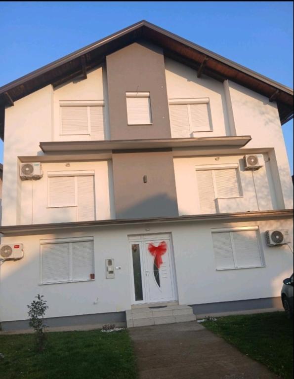 a large white house with a red bow on the door at Stan na dan Ugljevik Centar in Ugljevik