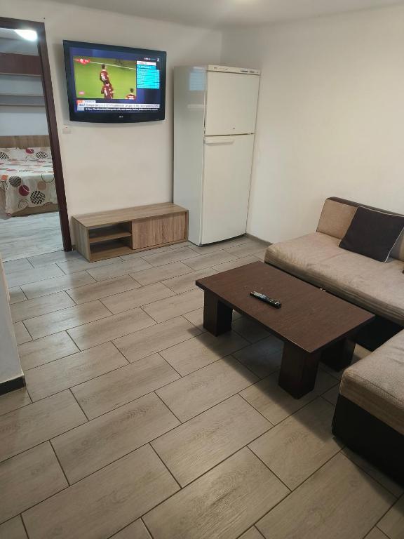 a living room with a couch and a table and a tv at Casa Razu G2 in Craiova
