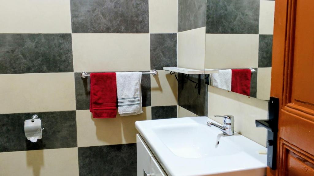 Un baño con un lavabo blanco y toallas rojas. en Appartement Néoclassique centre -ville, en Casablanca