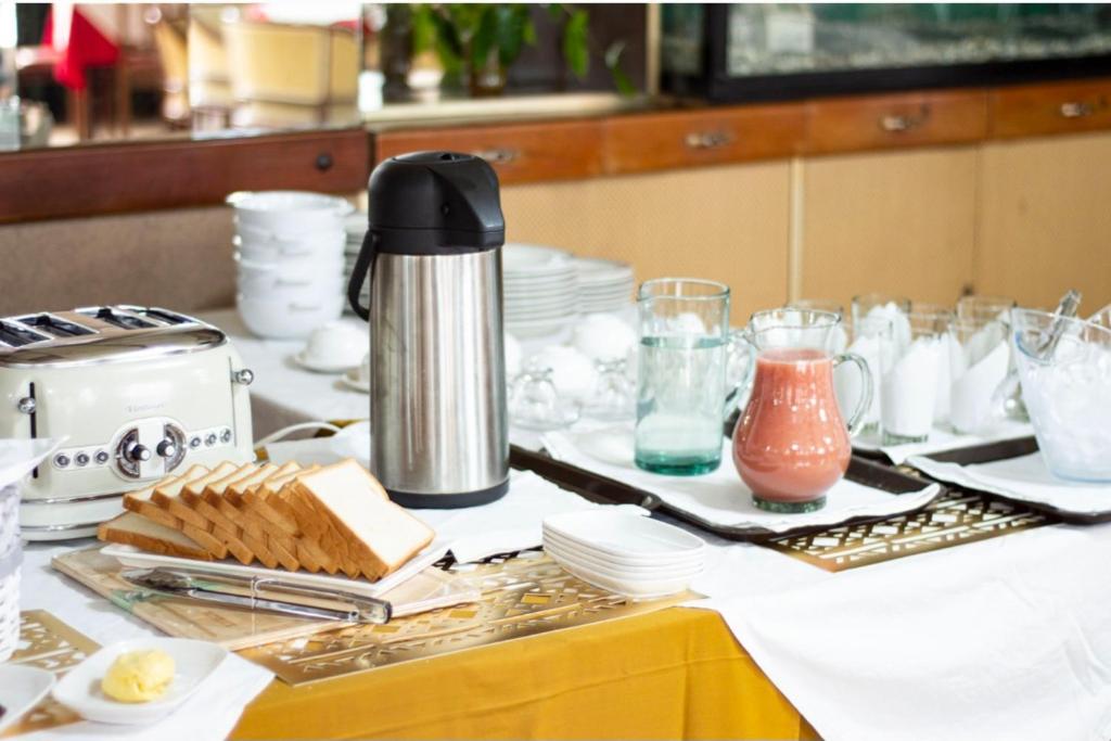 a table with dishes and a coffee maker on it at Hotel Dinastía in San Cristóbal