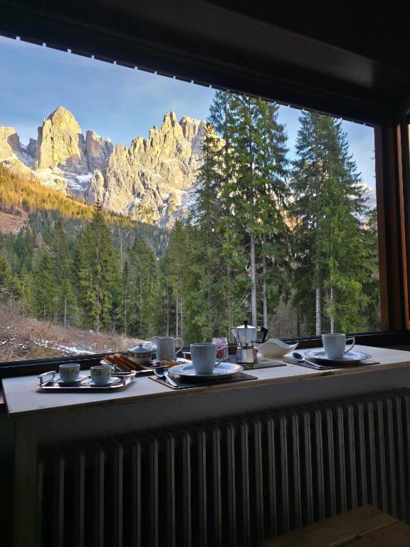 ein Tisch mit Blick auf die Berge aus einem Fenster in der Unterkunft Hope Home Trentino in San Martino di Castrozza