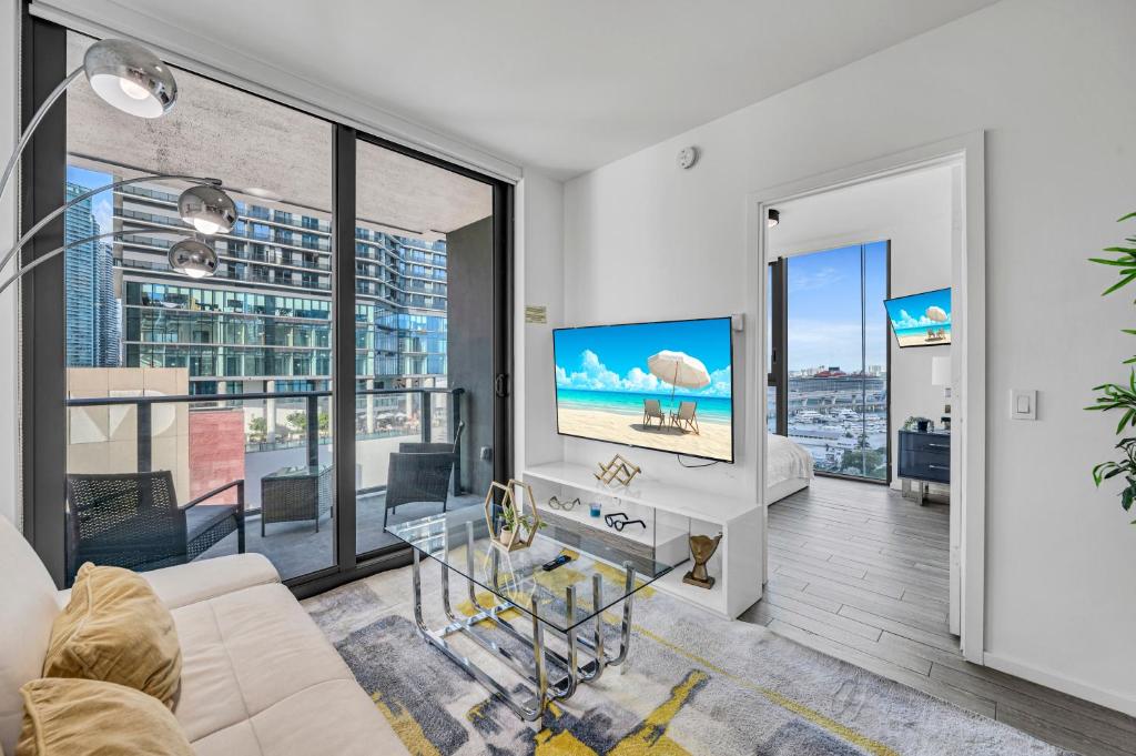 a living room with a couch and a tv at Waterline Corner Vies 2Br 2BA Suites in Miami