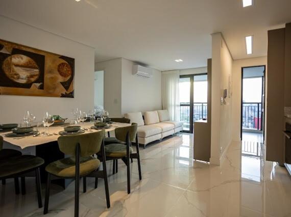 een woonkamer met een tafel, stoelen en een bank bij Solar Explore Botanico in Curitiba