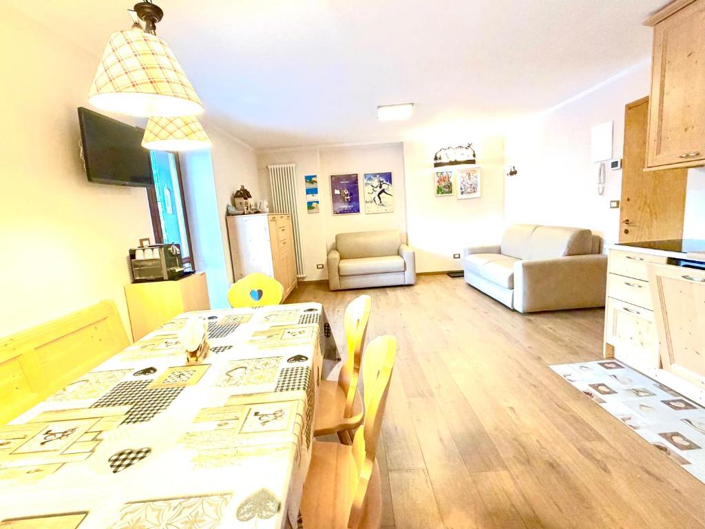 a kitchen and living room with a table and chairs at EMARGHE, CASA A MOENA in Moena