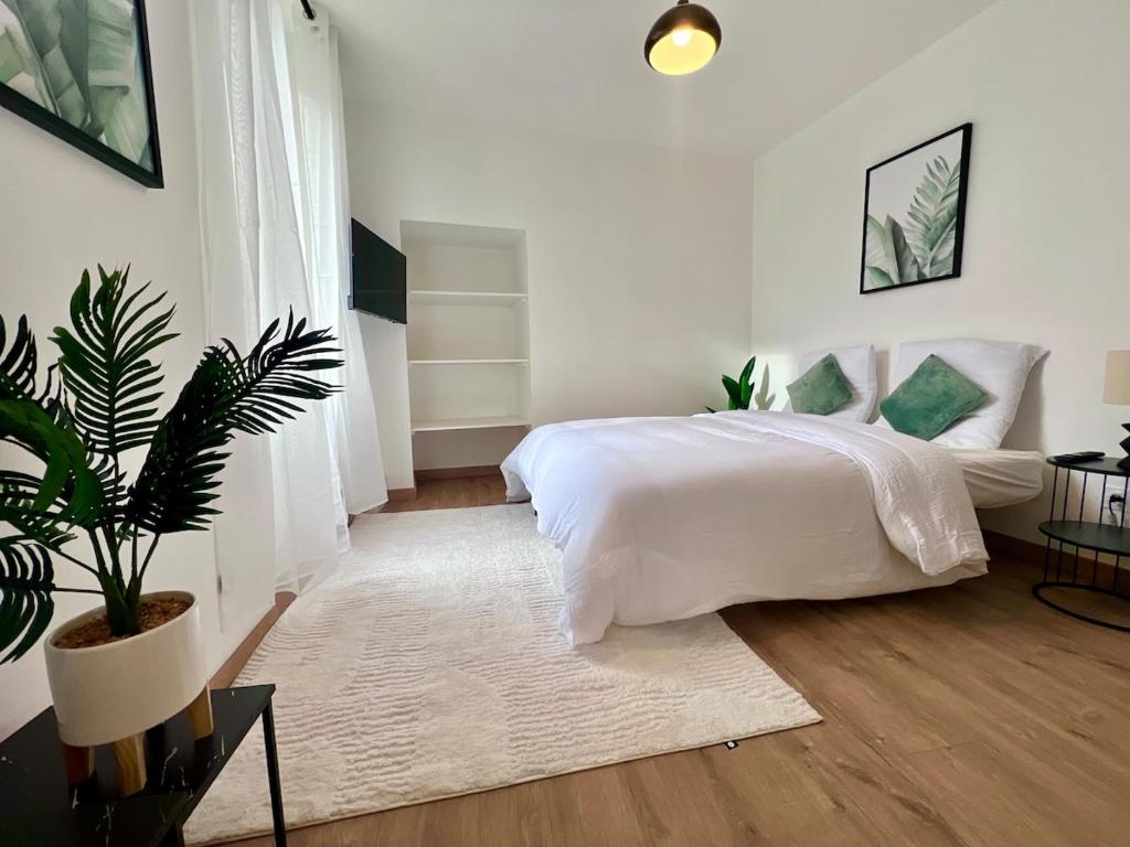 Un dormitorio con una cama blanca y una planta en maceta. en Doux Pavillon - La suite Hirvi - Hyper centre, en Roanne