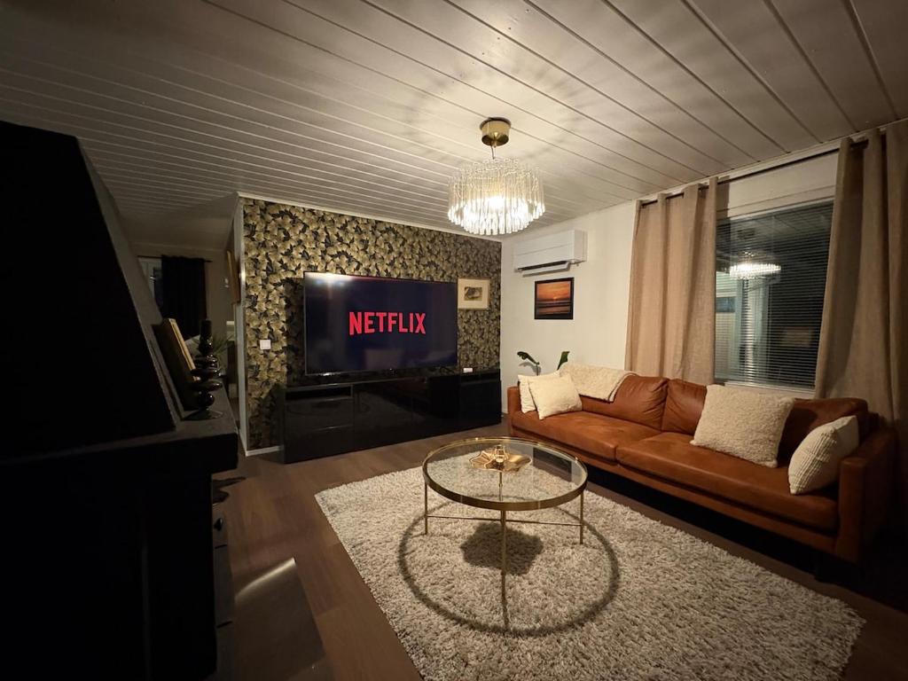 Una sala de estar con un sofá y un televisor. en Cozy house near the river - sauna, Wi-Fi, en Tornio