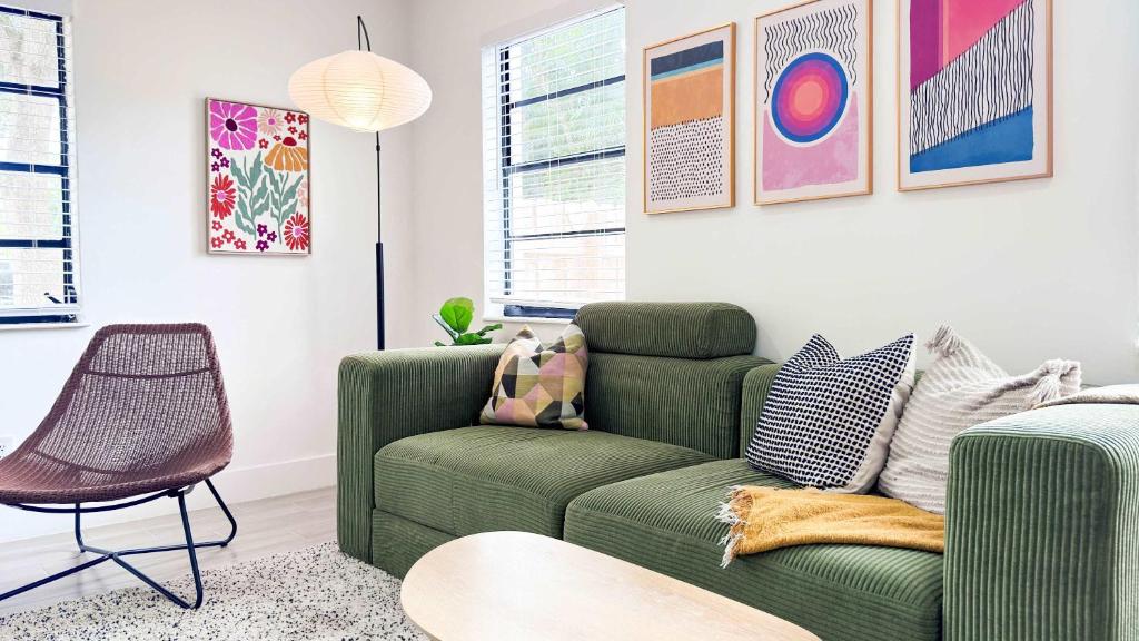 een woonkamer met een groene bank en een stoel bij Cloud Nine - Wilton Drive Jacuzzi Backyard in Fort Lauderdale