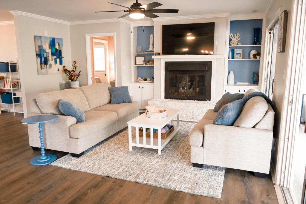 a living room with two couches and a fireplace at The Salty Lime in Emerald Isle