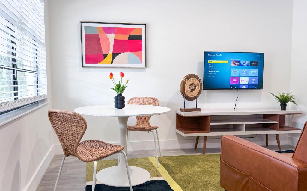 een woonkamer met een tafel en een tv bij The Hideaway - Wilton Manors in Fort Lauderdale