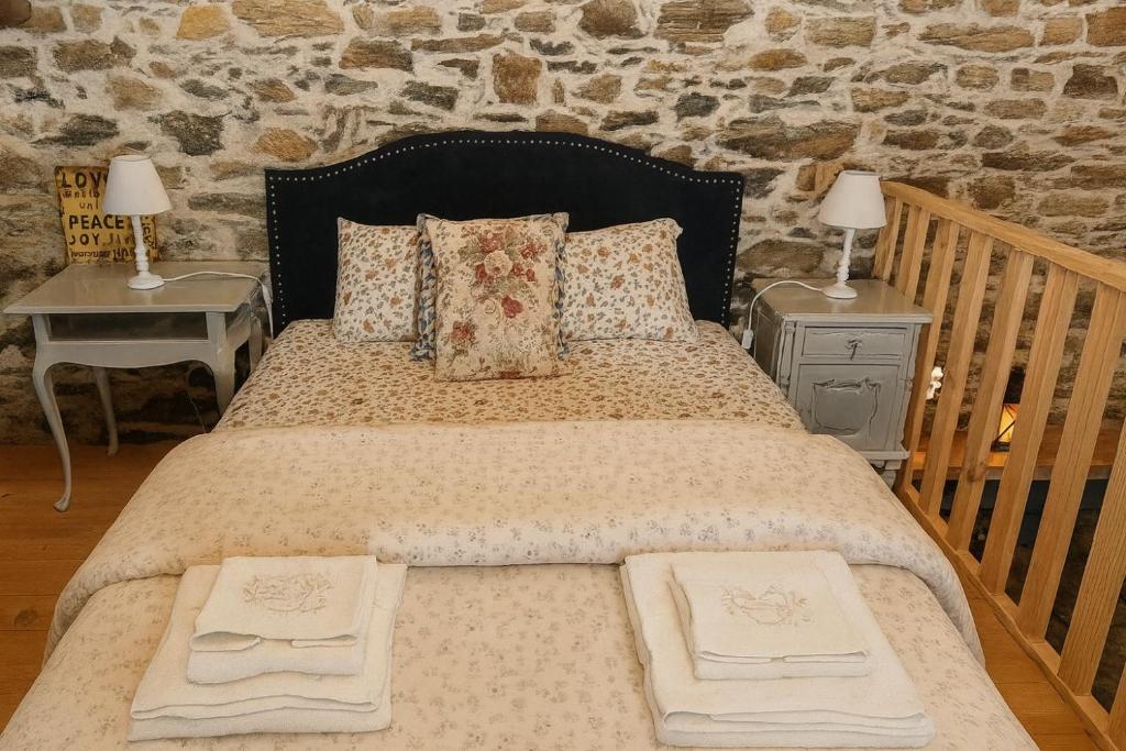 a bedroom with a large bed with two tables and two lamps at Ceira Cottage - Refúgio Romântico com Vista Serrana in Góis