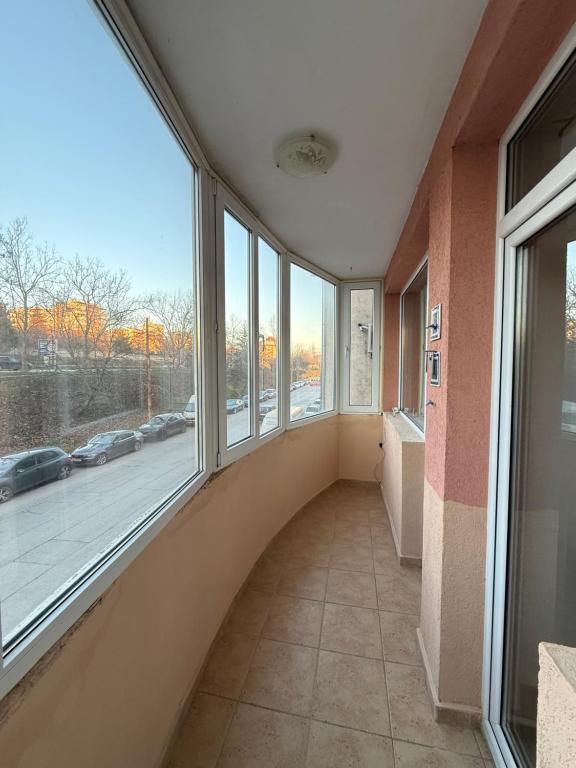 ein leerer Flur mit Fenstern und Blick auf eine Straße in der Unterkunft Vasi City Stay in Weliko Tarnowo