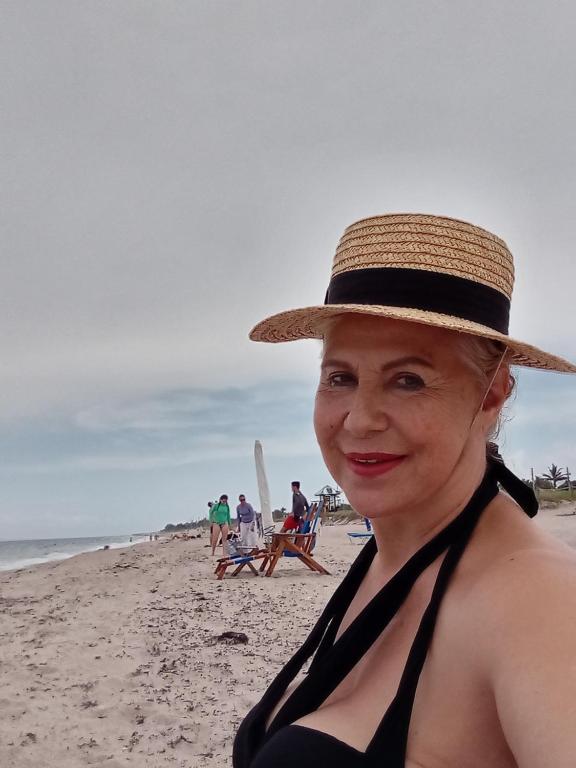 een vrouw met een strohoed op het strand bij LakePoolBeachVacatuonHouse225d9Prs 