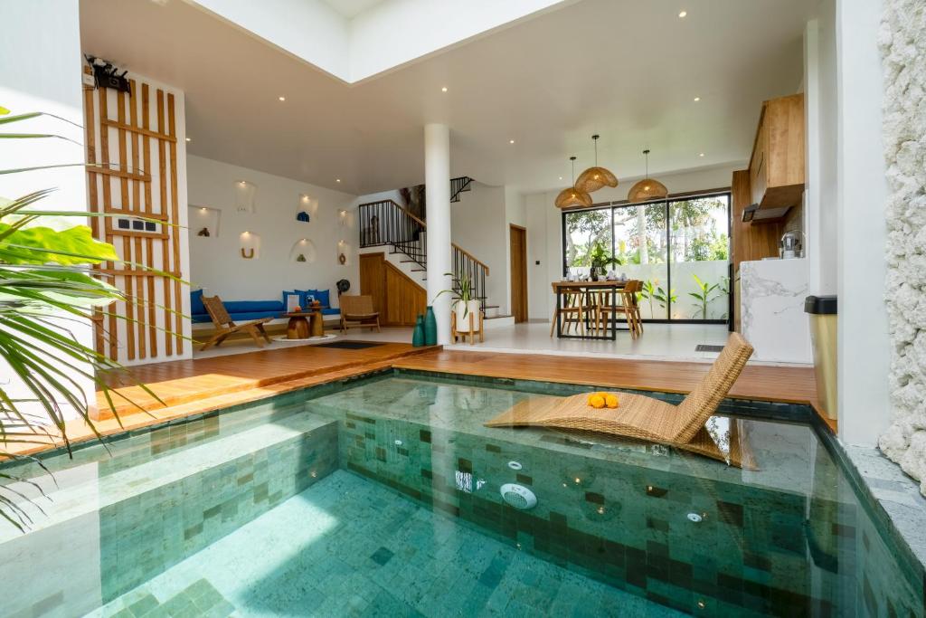ein Swimmingpool in einem Haus mit Wohnzimmer in der Unterkunft Bali Taoka Villa Tanah Lot in Tanah Lot