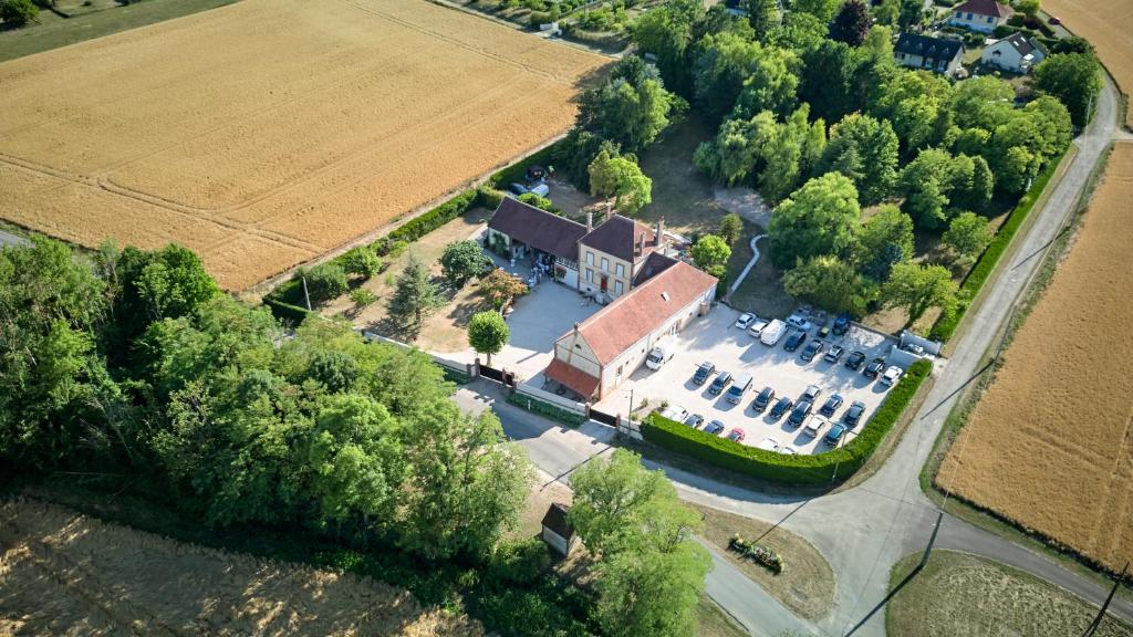una vista aérea de una granja con un campo en Suite avec balnéothérapie, en Montholon