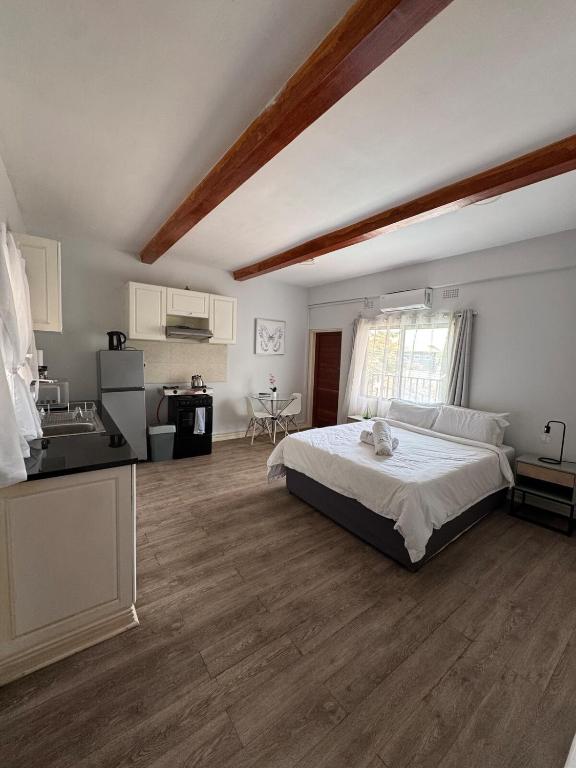 a large bedroom with a bed and a kitchen at The Uptown studio in Lusaka