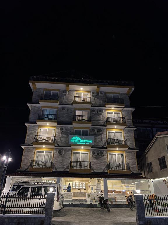 a tall building with lights on it at night at Hotel mustang in Jomsom
