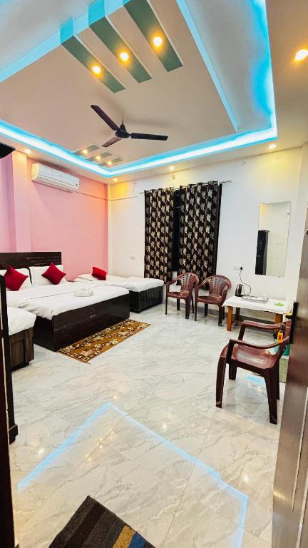 a room with beds and chairs and a ceiling at devkritii innn stays in Faizābād