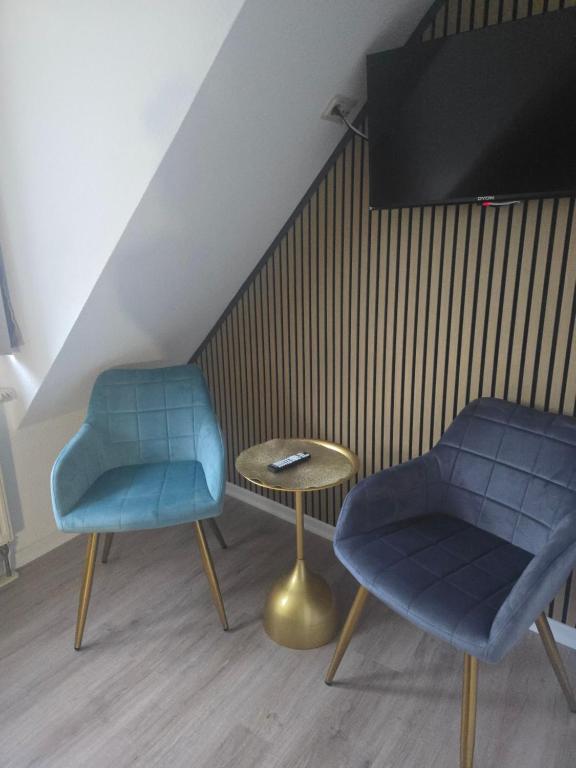 two chairs and a table in a room at Hotel & Restaurant Hasa in Gernrode - Harz