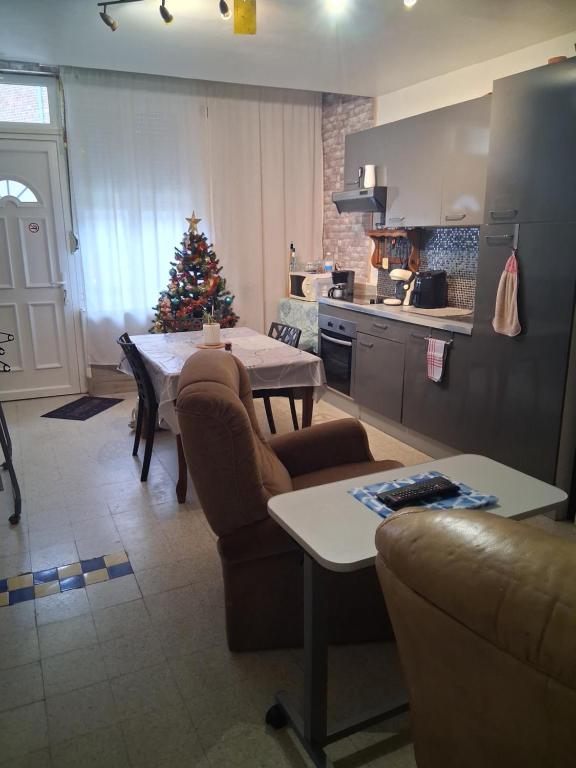 una cocina con un árbol de Navidad, una mesa y sillas en Un moment d'évasion, en Aulnoye-Aymeries