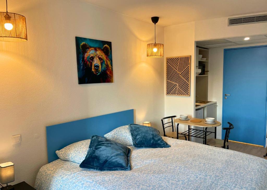 een slaapkamer met een bed met een schilderij van een beer bij Tanière Bleue - OFFER - Clim - Wifi in Lourdes