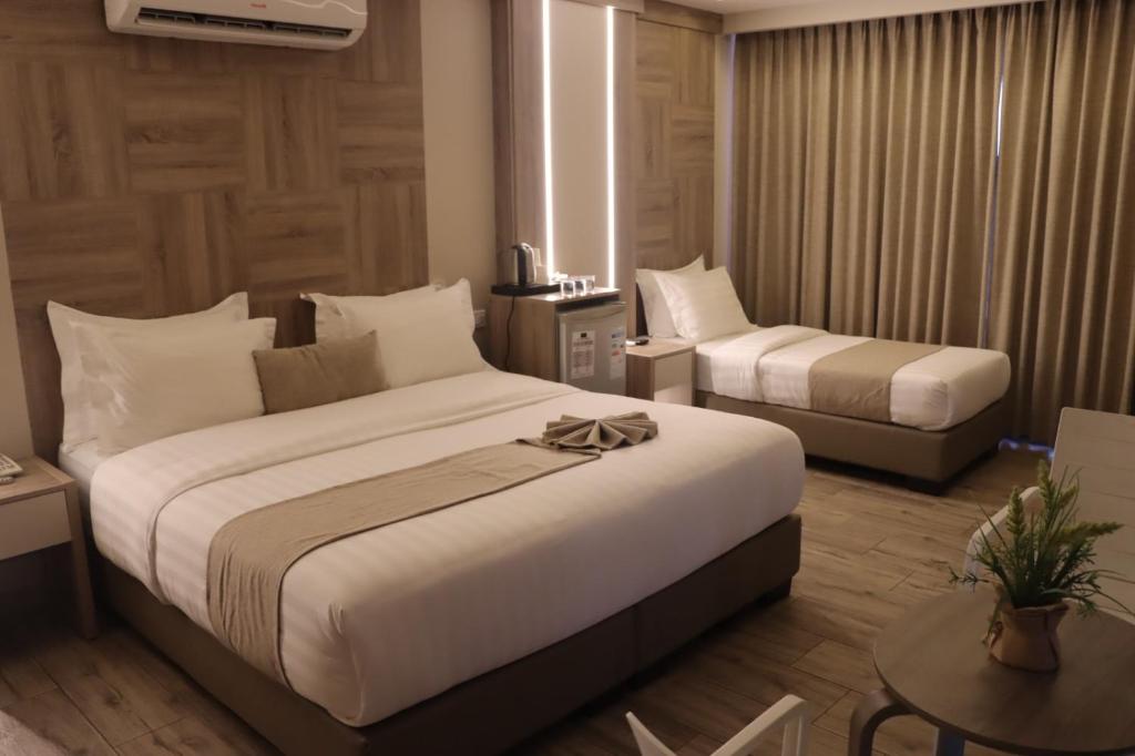 a hotel room with two beds and a table at Alena Boutique Hotel in Aqaba