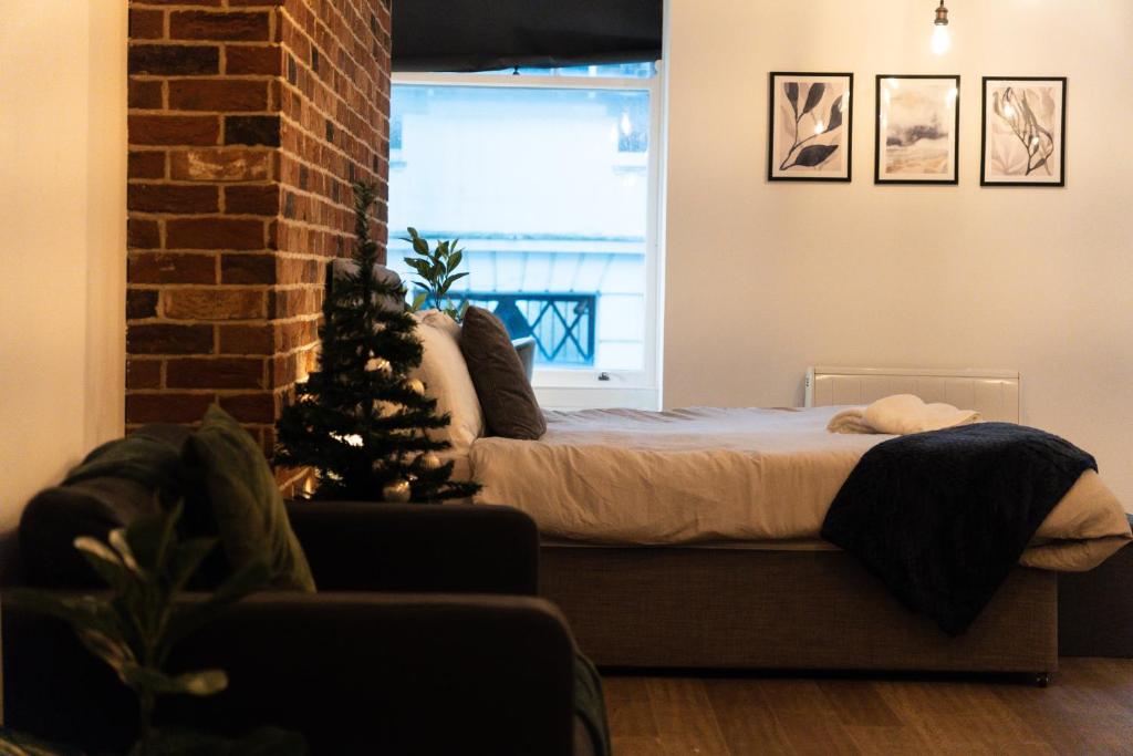 a bedroom with a bed with a christmas tree in it at Chic Brighton Studio in Brighton & Hove