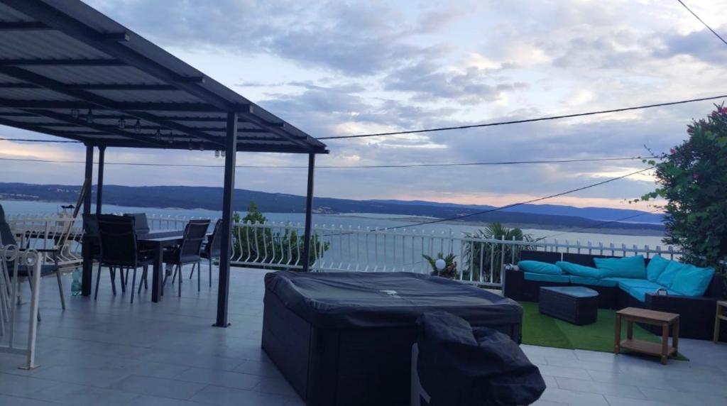 a patio with a table and chairs and a view of the water at Apartman Dramalj in Dramalj
