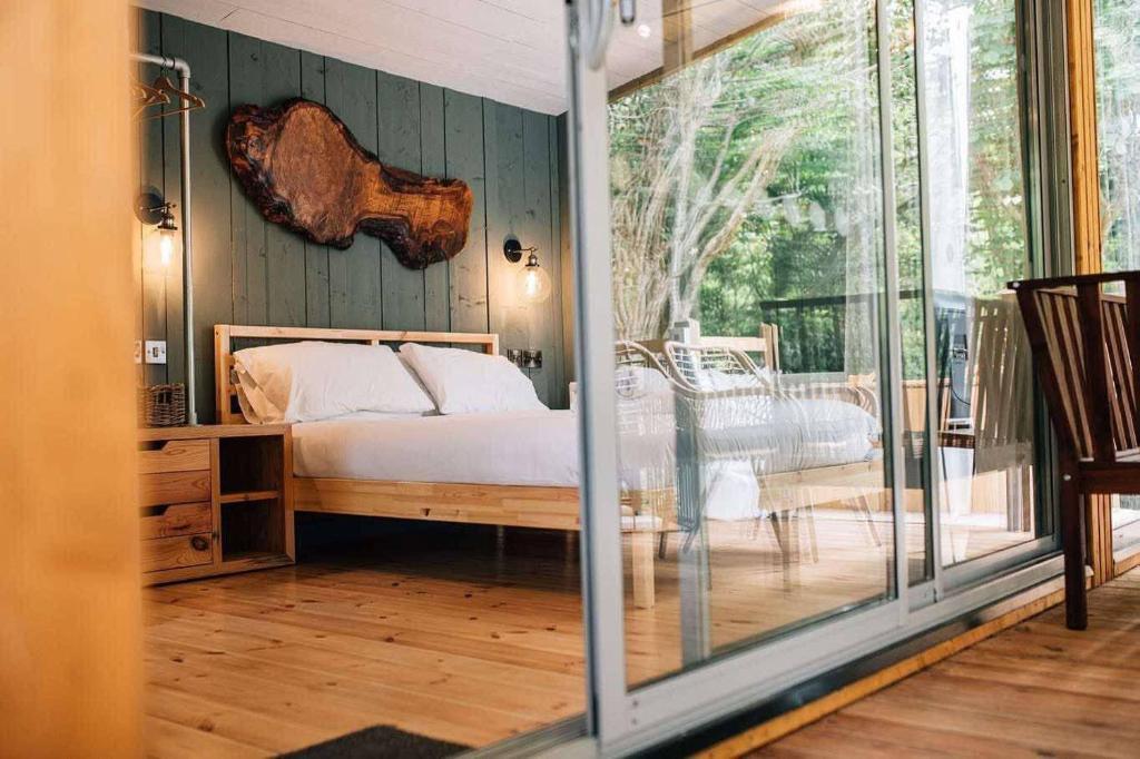 a bedroom with a bed and a sliding glass door at Waters Edge Spa in Carryduff