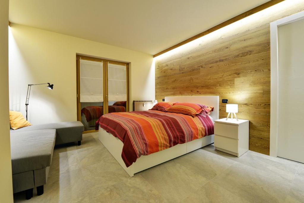a bedroom with a bed and a chair and a mirror at Le Reve de Marisa in Morgex