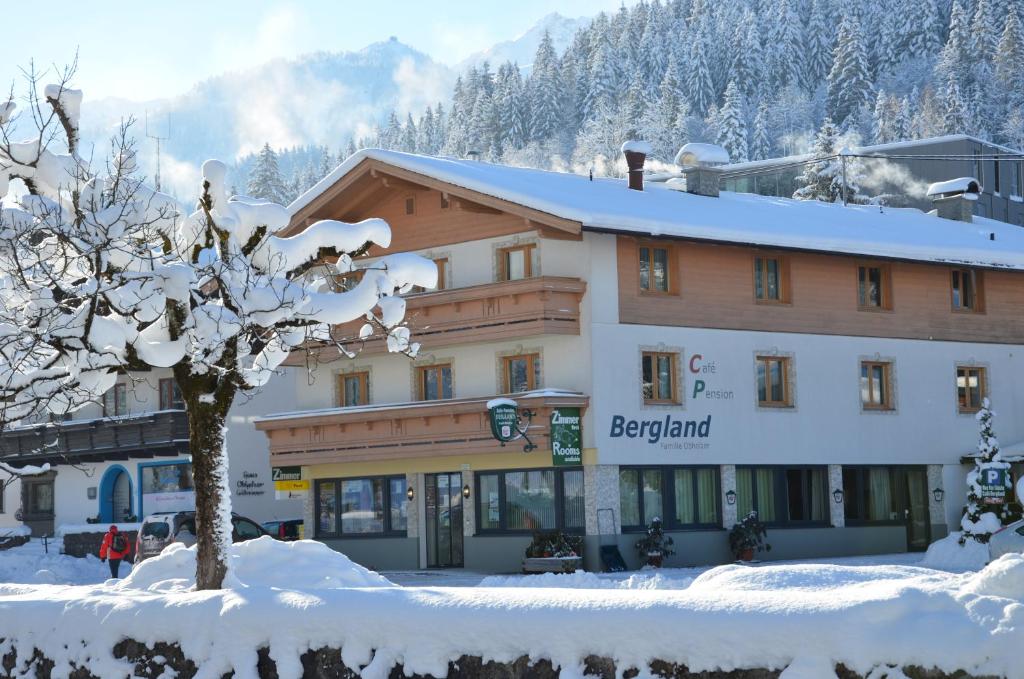 een groot gebouw in de sneeuw met een boom bij Haus Bergland in Fieberbrunn