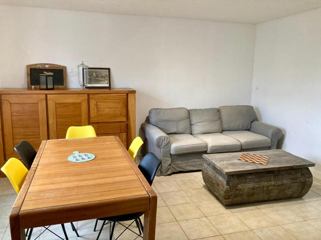 un soggiorno con un divano e un tavolo di La Longère a Vierzon