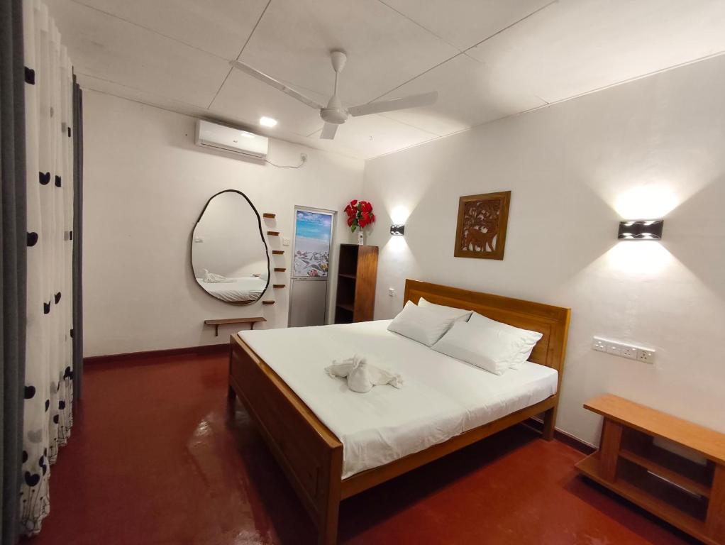 a bedroom with a bed and a mirror at Ayuvilla in Goiyapana