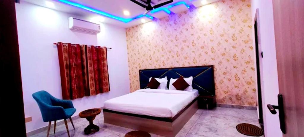 ein Schlafzimmer mit einem Bett und einem blauen Licht in der Unterkunft Hotel Premimum Kashi Satya Luxury-Parking Facility #Near KASHI VISHWANATH TEMPLE# in Varanasi