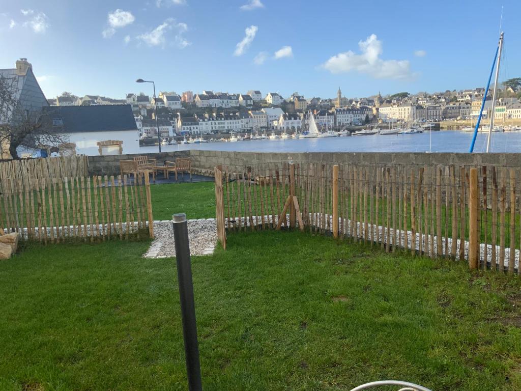 una valla en un patio con vistas al agua en Appartement avec son jardin face au port d'Audierne, en Plouhinec